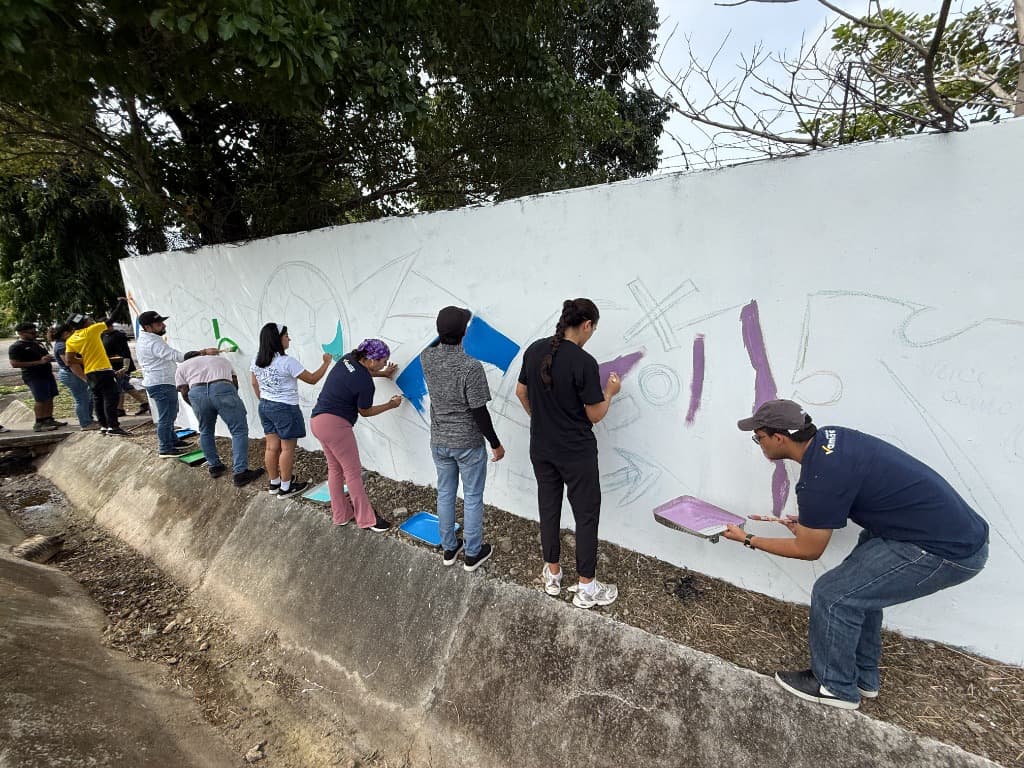 Jóvenes y voluntarios pintando mural comunitario en Juan Díaz